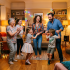 Multigenerational family members dancing and laughing in a warmly lit living room with decorations